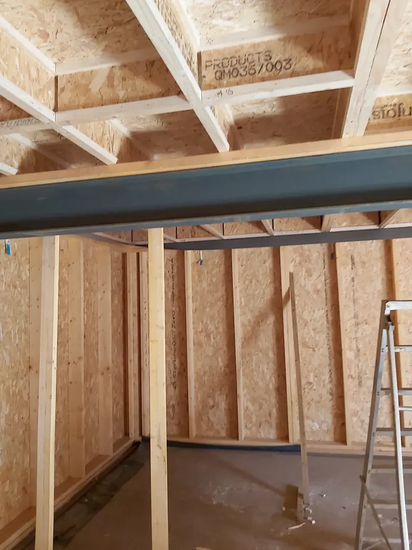 Timber-framed room showing structural walls, ceiling joists and joinery work