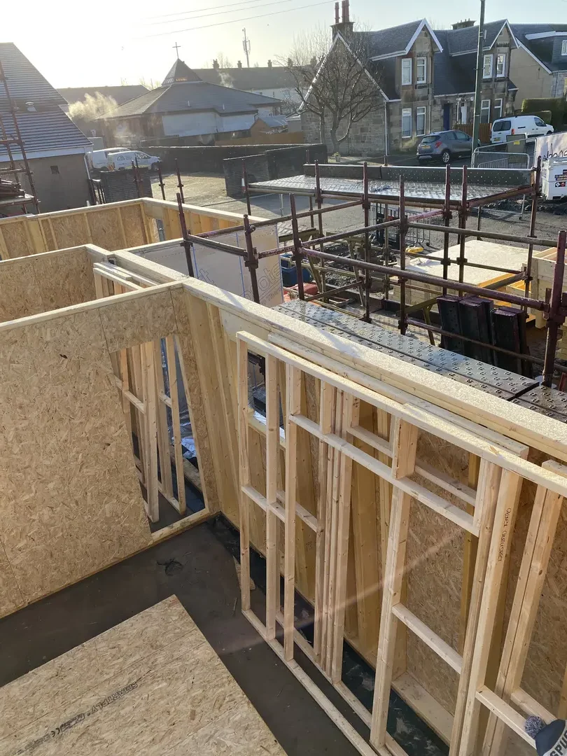 External timber-framed walls and window openings under construction