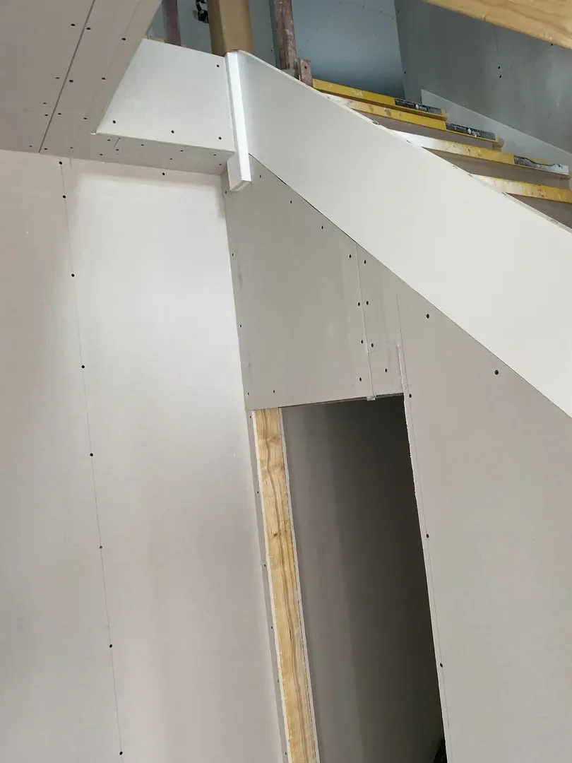 Plasterboarded stairwell prepared around a newly fitted staircase