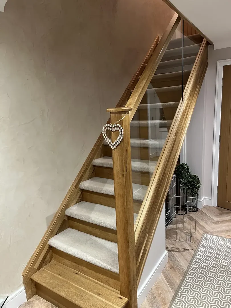 Completed oak staircase with white risers and timber handrail