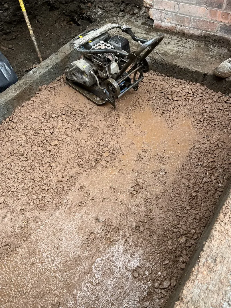 Excavated and compacted base prepared for extension foundations