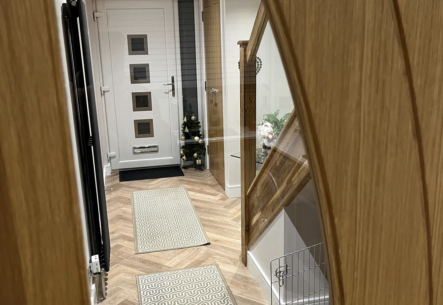 Finished hallway with oak staircase and glass balustrade