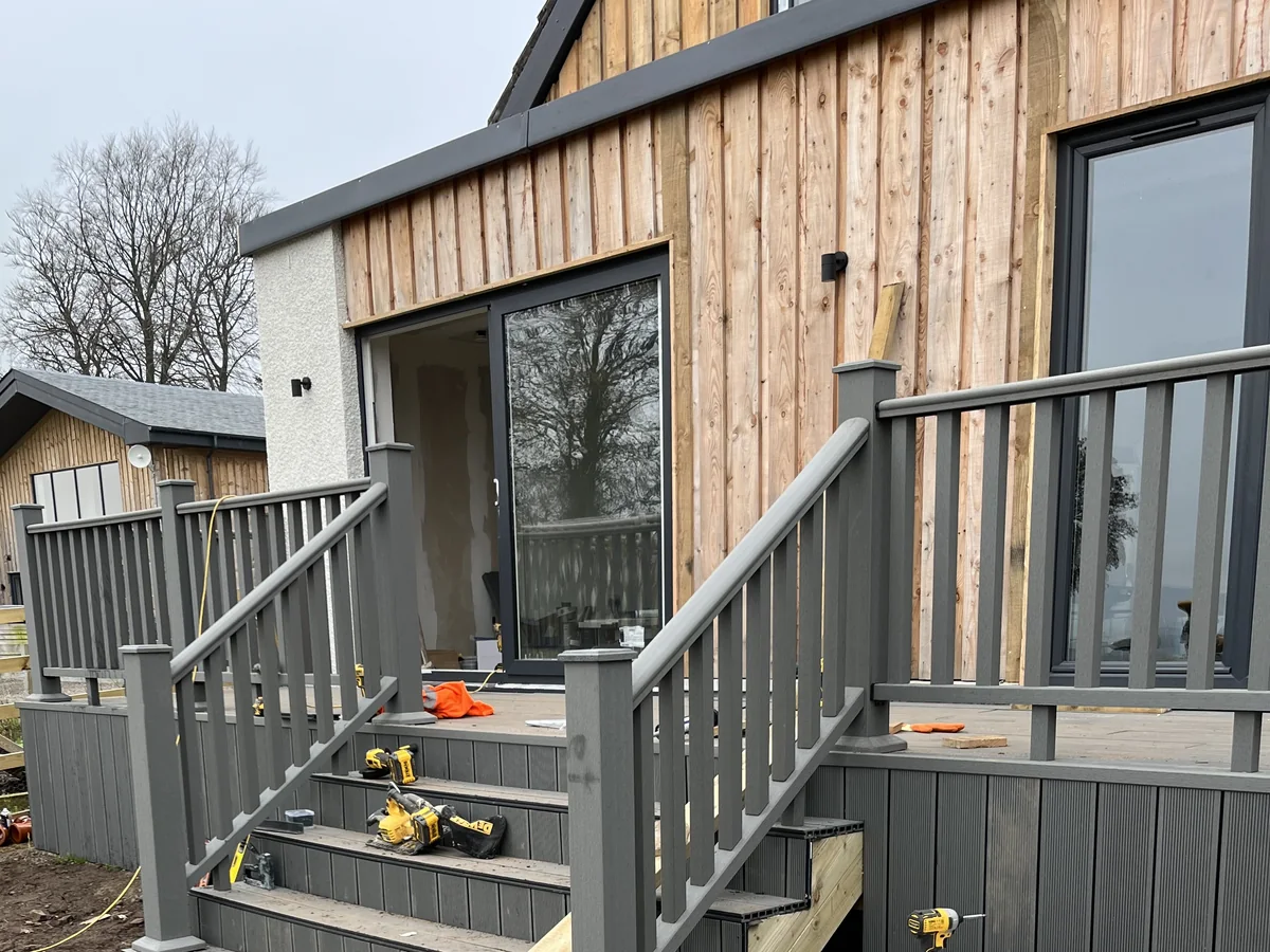 Timber-clad extension and composite decking under construction